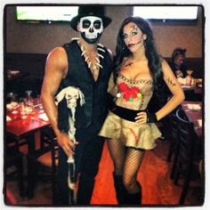 a man and woman dressed up as skeletons at a restaurant table with tables in the background