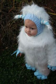 a baby dressed in a white and blue costume