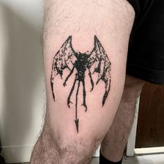 a man with a bat tattoo on his leg