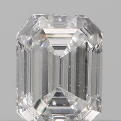 an emerald cut diamond on a white surface with the center stone in between two smaller diamonds