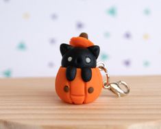 an orange and black cat keychain sitting on top of a wooden table