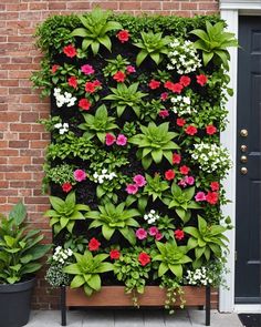 a vertical garden with flowers and plants growing on the side of a brick wall in front of a door