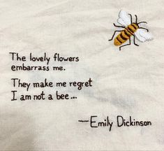 embroidered quote on white linen with bee and words in black ink, the lovely flowers embarras me they make me forget i am not a bee