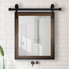 a bathroom mirror hanging on the wall above a sink