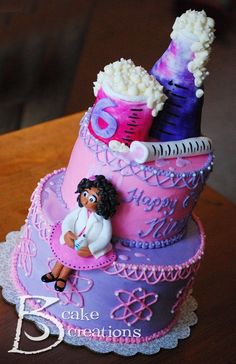 a purple and pink cake with an afro woman sitting on the bottom tier, surrounded by other items