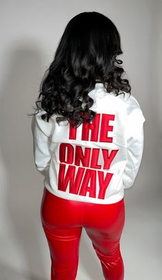 a woman wearing red pants and a white sweatshirt with the words i the only way printed on it