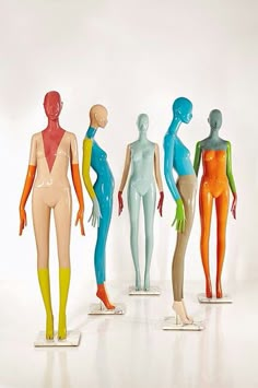 five mannequins with different colored body shapes and colors on display against a white background