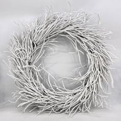 a white twig wreath sitting on top of a table