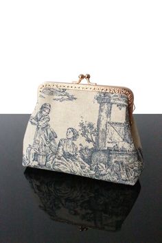 "You search a small original present for your familie  (child, mom, granny, sister)? Here is our collection of Toile de jouy cosmetic  bag with  kisslock frame for women - trend for 2024.  Can also be used as a small cosmetic bag or makeup bag not taking up much space in your handbag, or as a small storage kit. And why, not just as an object of decoration. Some Toile de jouy makeup bag are can also used as a small pouch. You will enjoy quality materials (Linen fabric, Toile de jouy, tweed fabric, French tapestry, wool fabric, velvet corduroy, Japanese cotton). Handmade bag with 100% linen fabric.  * 100% Toile de jouy * Inside 100% coton/linen fabric    * Interfacing  for structure Height 5,1\" Length  5,9\" Depth  1,6\" Frame kiss lock Golden hardware 4,9\" Only 1 in stock! Made in France Makeup Bag Vintage, Vintage Cosmetic Bag, Vintage Makeup Bag, Vintage Bag Pattern, Navy Blue Clutch, Unique Clutch, Small Cosmetic Bag, My Style Bags, Luxury Bags Collection