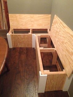 an open drawer on the side of a wooden table in a room with hard wood flooring