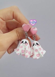 two little white dogs with pink hearts hanging from their earring sets in the shape of hearts