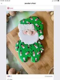 a cookie decorated like santa claus on a cutting board with sea shells and garlic in the background