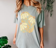 Yellow Wildflower  Floral Comfort Colors T Shirt Hi and welcome to Charley Anne Designs! This is a beautiful Comfort Colors unisex T-shirt.  *For an oversized look please size up 1-3 sizes* Review the sizing chart to make sure you purchase the size/fit you want.  This cute and boho floral Tee is perfect for summer! it is comfortable, casual, and effortlessly cute! You are going to love styling this groovy floral t-shirt all summer long! I personally love wearing these with cut off denim shorts, or with a comfy pair of leggings! Washing and Care Instructions These shirts are 100% ring spun cotton Wash in cold water Do not bleach Do not iron directly on design Production Time 2-3 business days Please Note: The Model is wearing a size Large. The images are scaled down for medium and small t-s Yellow Wildflowers, Oversized Look, Floral Tee, Trendy Graphic Tees, Comfort Colors Tee, Short En Jean, Boho Floral, Sizing Chart, Tshirt Colors