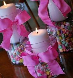 two glass vases filled with candy and candles