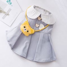 a dress with buttons and a bear on it