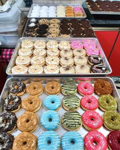 two trays filled with assorted donuts on top of each other in different flavors