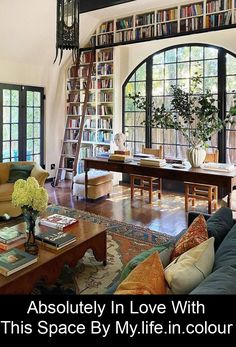 a living room filled with furniture and bookshelves next to a window that reads absolutely in love with this space by my life in color