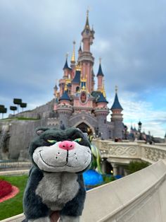 a close up of a stuffed animal near a castle