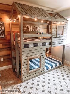 a child's bed made out of wooden pallets with lights strung from the roof