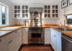 a kitchen with white cabinets and stainless steel appliances