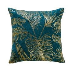 a blue and gold pillow with palm leaves on it