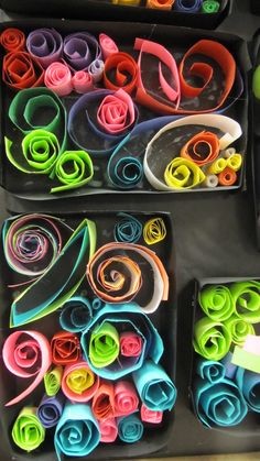 two trays filled with different colored rolled up paper