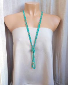 "Long turquoise necklace, boho tassel beaded necklace, v necklace. The knot is adjustable, simple to undo and redo at the height you would like! Or you can wear the necklace double up without any knot! It is a very versatile necklace that can be adapted to your taste.   ❤ PROCESSING AND SHIPPING Most orders are made and shipped out in one business day. Please check delivery timeframes for your location on the description below.  ❤ CUSTOM ORDERS If you like this item in a different color, send me a message indicating: color, size and quantity needed. I will send you a link for a \"custom order\" and you'll be able to place the order there.  If you like this item with some variations such as thickness or style, please also send me a message and I will work with you! Go back to my shop: https Turquoise Lariat Beaded Necklace For Festival, Turquoise Bohemian Tassel Necklace, Turquoise Beaded Necklaces With Tassels For Gift, Turquoise Necklaces With Tassel And Round Beads, Turquoise Necklace With Tassels And Round Beads, Turquoise Beaded Necklace With Tassels And Round Beads, Turquoise Beaded Necklace With Tassels, Adjustable Turquoise Tassel Necklace With Round Beads, Adjustable Turquoise Tassel Necklaces