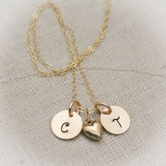 "Perfect gift for couples or if for a mother with two children. Two 3/8\" 14K gold filled hand stamped initial of your choice paired with a 14K gold filled heart charm. Comes with a 14K gold filled link chain in 16\", 18\" or 20\". These would be perfect for a bridal party. ---------------------------------------------------------------------------------- **Remember, when ordering list the following: Initials ----------------------------------------------------------------------------------- All Personalized Gold Initial Necklace As Gift For Mom, Personalized Gold Initial Necklace For Mom, Gold Initial Necklace Hand Stamped For Gift, Personalized Gold Charm Necklace For Mom, Gold Hand Stamped Initial Necklace Gift, Gold Hand Stamped Initial Necklace For Gift, Gold Hypoallergenic Charm Necklace For Personalized Gift, Personalized Hypoallergenic Gold Charm Necklace, Gold Personalized Heart Pendant Charm Necklace