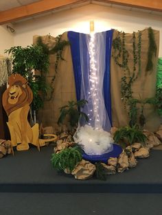 a lion themed birthday party with decorations and lights on the stage, including a fountain