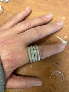 a person's hand with three rings on it