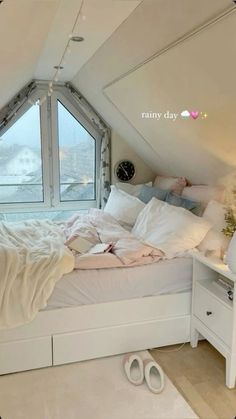 there is a bed in the attic with white sheets and pillows on top of it