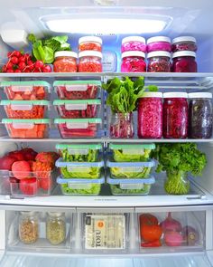 an open refrigerator filled with lots of different types of vegetables and food in plastic containers