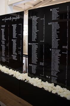 two black and white menus with flowers on the bottom one is for people to write their names