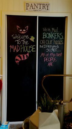 two blackboards with writing on them in front of a door that says welcome to the mad house