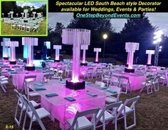 an outdoor event set up with purple lighting and white table cloths for the tables