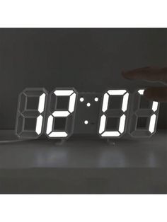 an alarm clock with the time displayed on it's display stand in front of a dark background