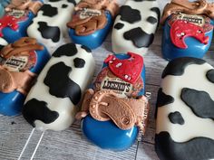 some chocolate cows are sitting on top of blue and white candy pops with red heart shaped candies in them