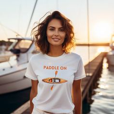 "Dive into adventure with our \"Paddle On\" t-shirt! This shirt is more than just fabric - it's an invitation to explore, to glide through life with a spirit of boundless curiosity. With a kayak design that captures the essence of motion on water, it's a reminder to keep pushing forward, embracing the currents of life. Wear it as a badge of your unstoppable journey, and let the waves of inspiration carry you. Let's \"Paddle On\" together! The unisex soft-style t-shirt puts a new spin on casual c Casual Short Sleeve T-shirt For Water Sports, Summer Water Sports Short Sleeve T-shirt, Casual Short Sleeve Tops For Water Sports, Graphic Print Crew Neck Top For Water Sports, Crew Neck Top With Graphic Print For Water Sports, Short Sleeve Graphic Print Tops For Water Sports, Casual Crew Neck T-shirt For Water Sports, Casual Graphic Print T-shirt For Water Sports, Kayak Design