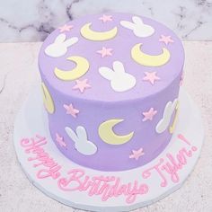 a purple birthday cake with white and pink decorations