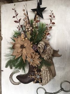 a cowboy boot decorated with flowers and greenery hangs from a hook on the wall