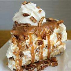 a piece of pecan pie with ice cream and nuts on top