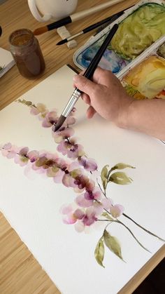 a person is painting flowers with watercolors