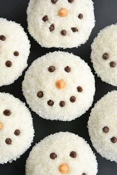 snowmen made out of rice krispy kreme treats on a black surface