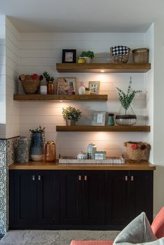 a living room filled with lots of shelves covered in vases and other items on top of them