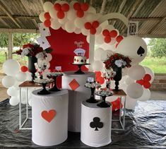 a table topped with lots of white and red balloons