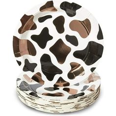 a set of four paper plates with black and white cow print on them, each plate has