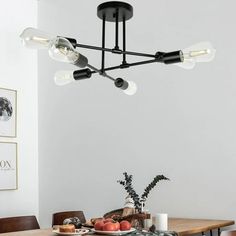 a dining room table and chairs with a light fixture hanging from it's ceiling