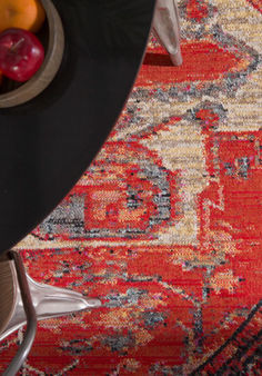 a table with fruit on top of it in front of a red and yellow rug