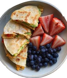 a white bowl filled with fruit and quesadillas