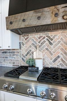 a stove top oven sitting inside of a kitchen next to a brick backsplash